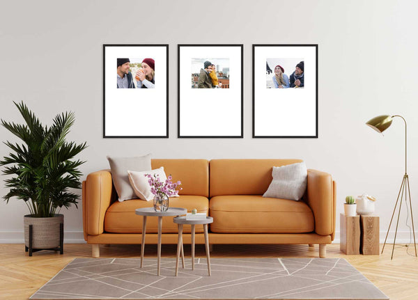 Living room with orange sofa and three framed photos on the wall.